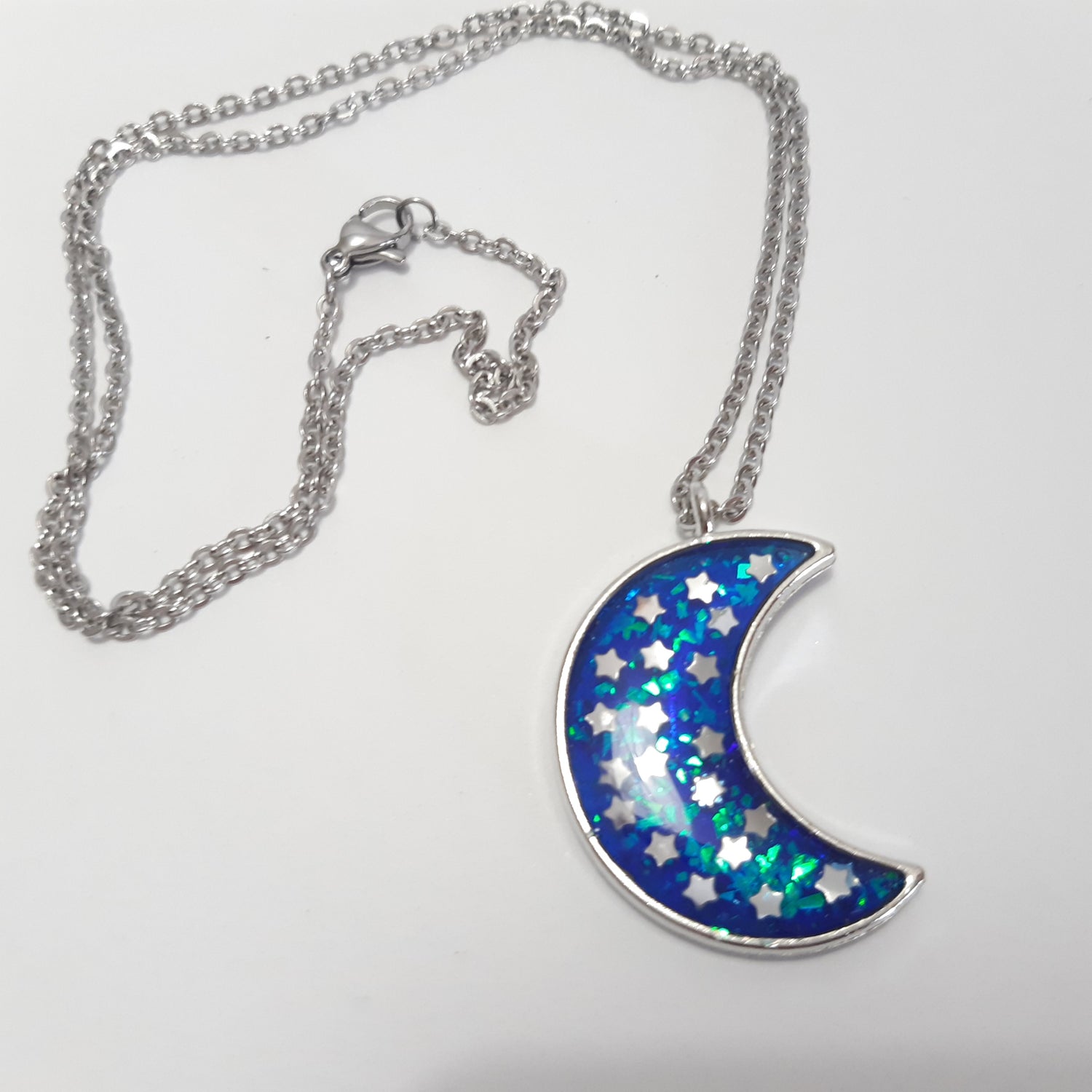 collier artisanal en résine en forme de lune de couleur bleue ornée d'étoiles argentées, en acier inoxydable argenté